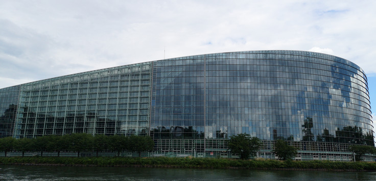 Gebäude des Europaparlaments vom Wasser aus gesehen.