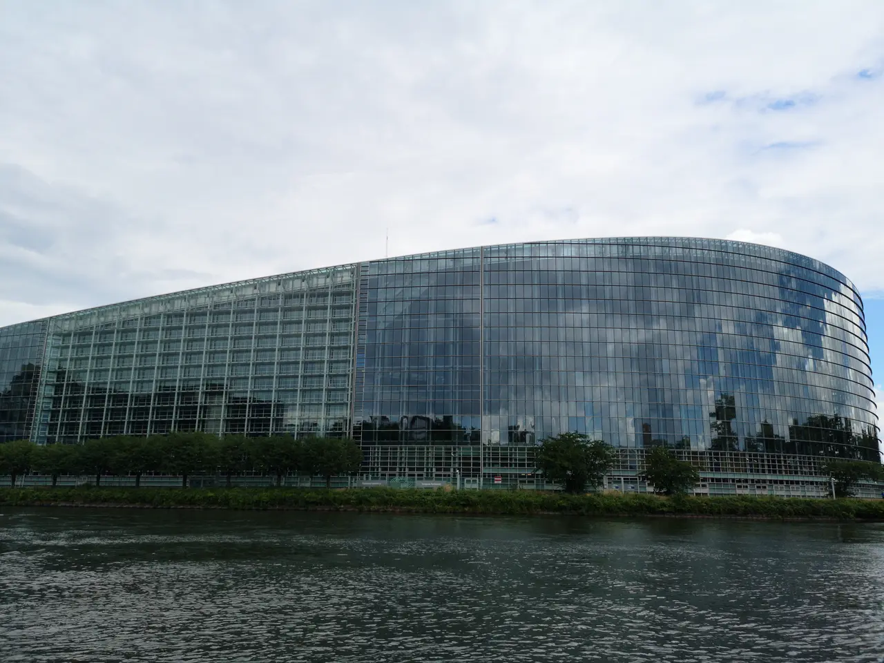 Gebäude des Europaparlaments vom Wasser aus gesehen.