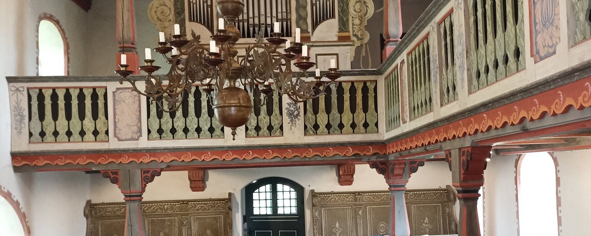 Auf dem Bild sieht man die Empore im Innenraum der Kirche in Zixdorf.