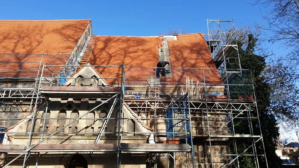 Hier sieht man, wie das Dach der Rehfelder Kirche neu eingedeckt wird.