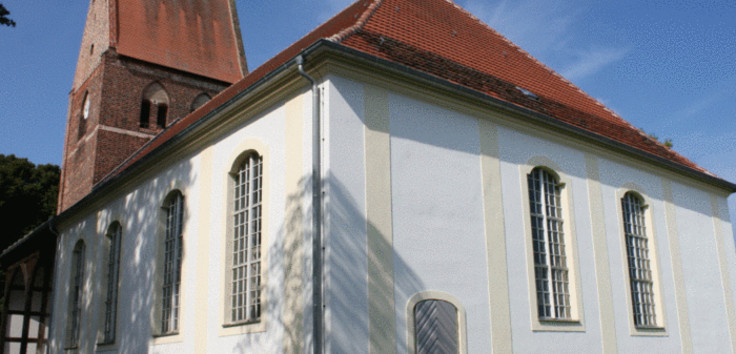 : Im Vordergrund des Bildes ist das sanierte Kirchenschiff zu sehen, links im Bild ist das Vordach erkennbar, welches die Radwegekirchen-Fähigkeit der Dorfkirche Pessin begünstigt.