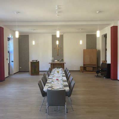 Man sieht einen langen tisch im Gemeinderaum des Gemeindehauses in Gransee (Brandenburg). Das Gemeindehauses in Gransee und wurde durch den Einbau einer Wärmepumpe energetisch saniert.