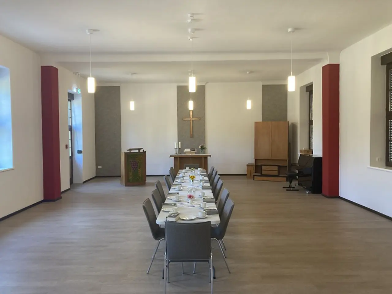 Man sieht einen langen tisch im Gemeinderaum des Gemeindehauses in Gransee (Brandenburg). Das Gemeindehauses in Gransee und wurde durch den Einbau einer Wärmepumpe energetisch saniert.