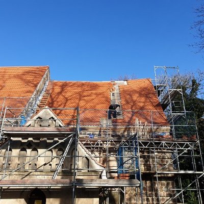 Hier sieht man, wie das Dach der Rehfelder Kirche neu eingedeckt wird.