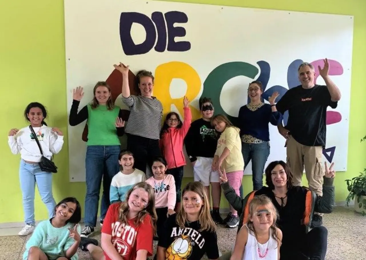 Vertreter:innen des "Berliner Ratschlags für Demokratie" besuchen die Kinderstiftung "DIE ARCHE". Auf dem Fotot winken sie in die Kamera.