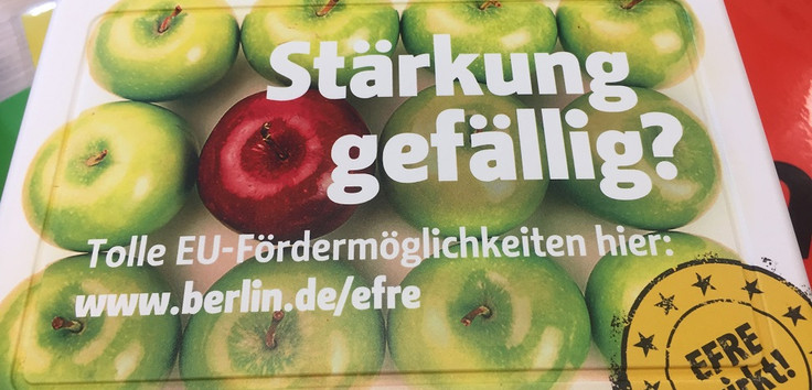 Auch die Öffentlichkeitsarbeit im Bereich ESF Berlin und EFRE Berlin war Thema beim Begleitausschuss Berlin. Foto: Johan Wagner; zu sehen ist eine Brotbox mit Apfelmotiv und einem EFRE-Aufkleber "EFRE wirkt".