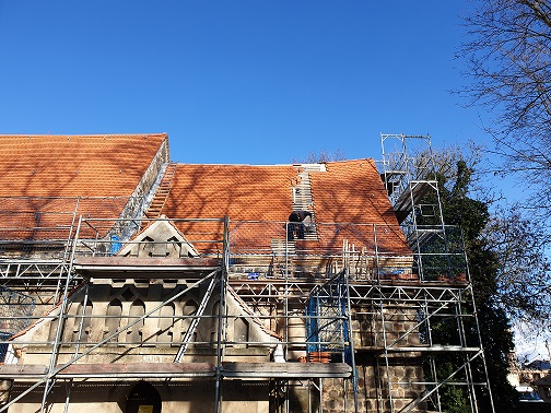Hier sieht man, wie im Zuge der Sanierung der Rehfelder Dorfkirche das Dach neu gedeckt wird.